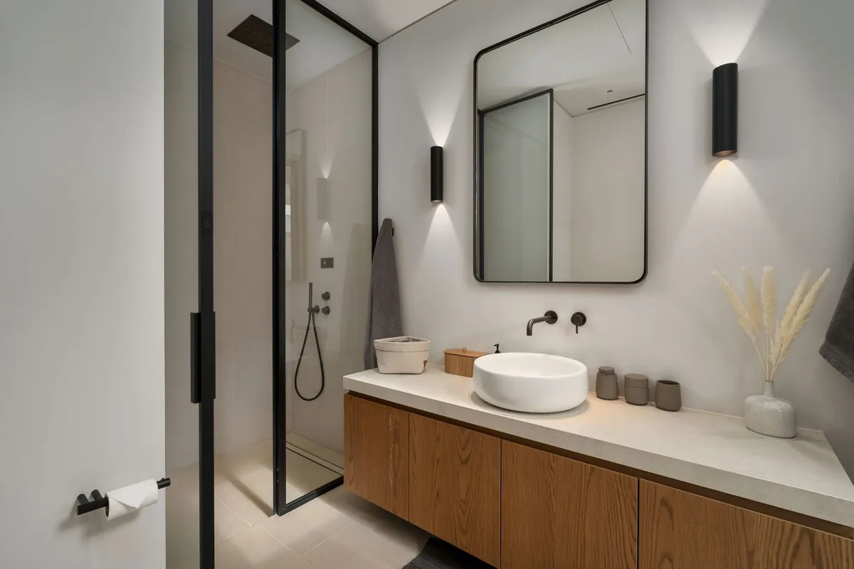 Badezimmer mit zwei Waschbecken und Waschtisch aus Holz