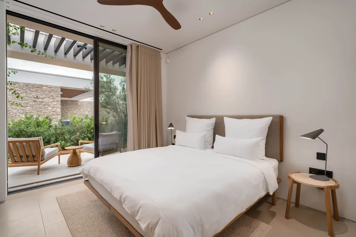 Bedroom with terrace access, linen bedding and timber detailing
